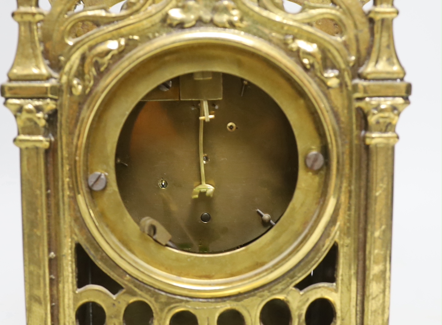 A Gothic style brass timepiece, 28cm tall, with key